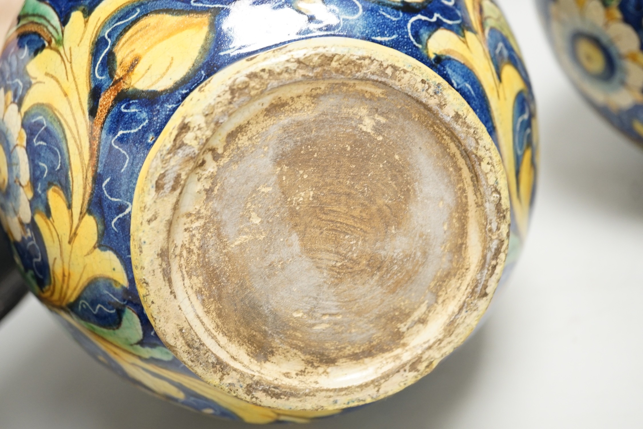 A pair of Italian maiolica flower and fruit painted jars, 22cm tall
